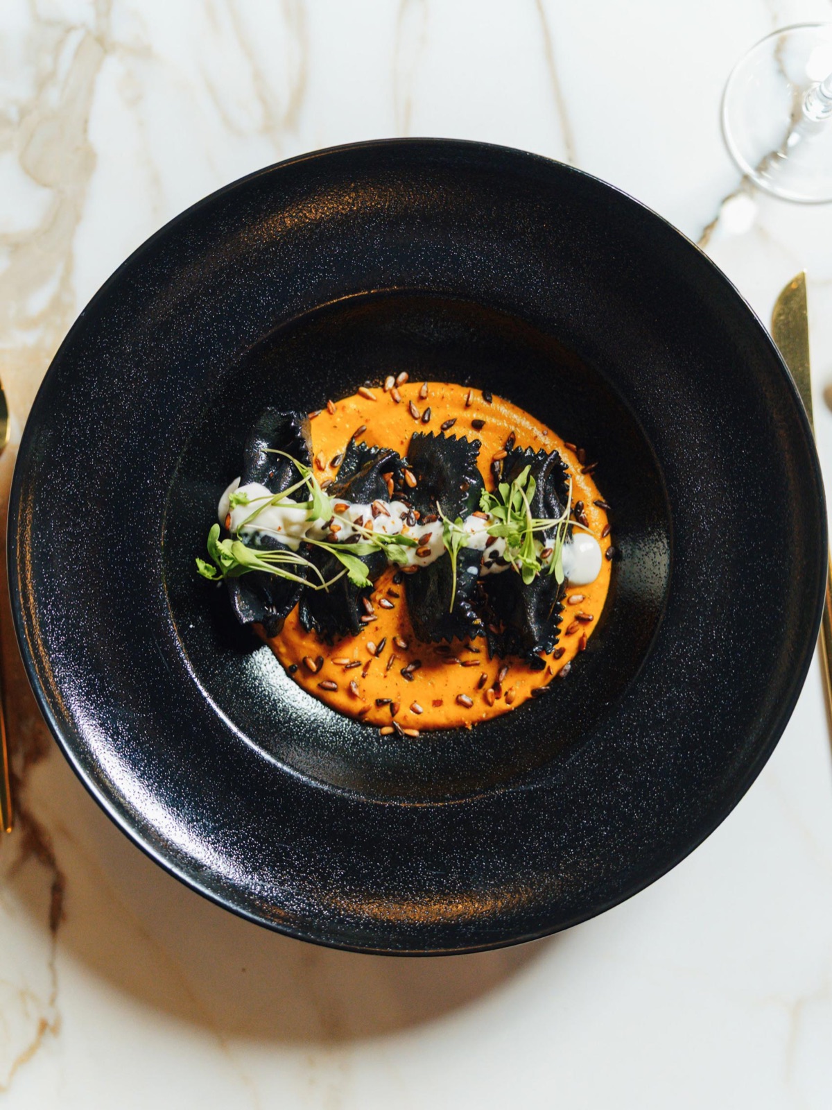 Black pasta over roasted carrot, sunflower seeds and micro herbs