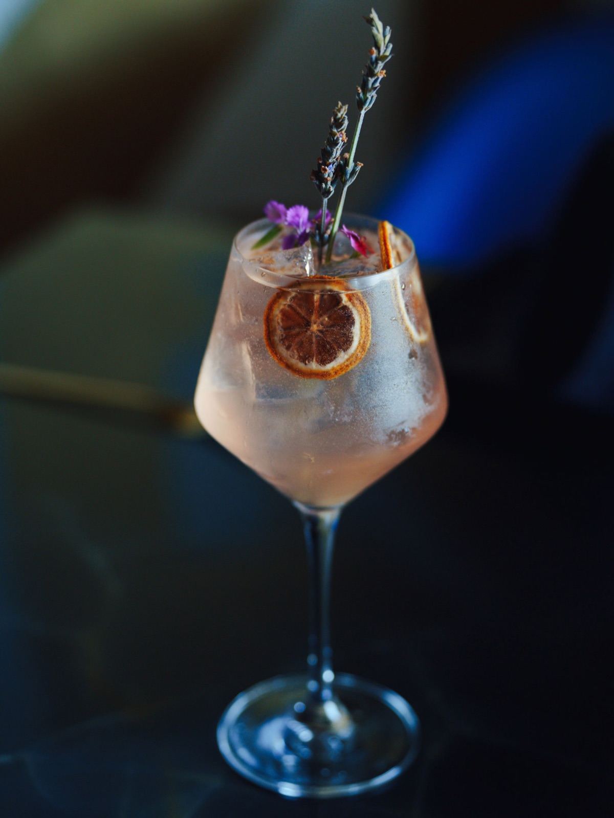 Cocktail with dried citrus and lavender in a stemmed glass